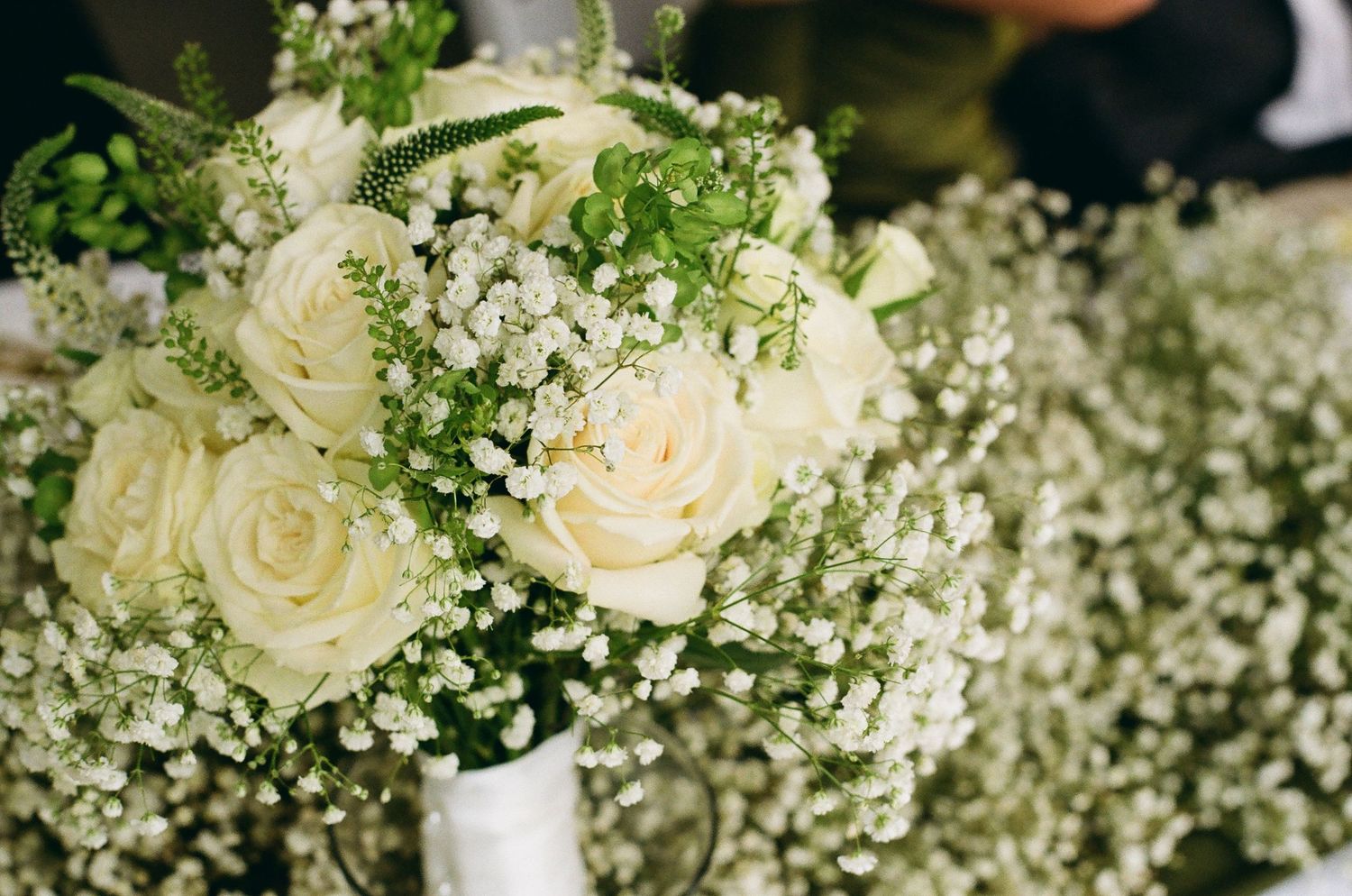 White roses and baby's breath bridal bouquet arrangement for a wedding ceremony.