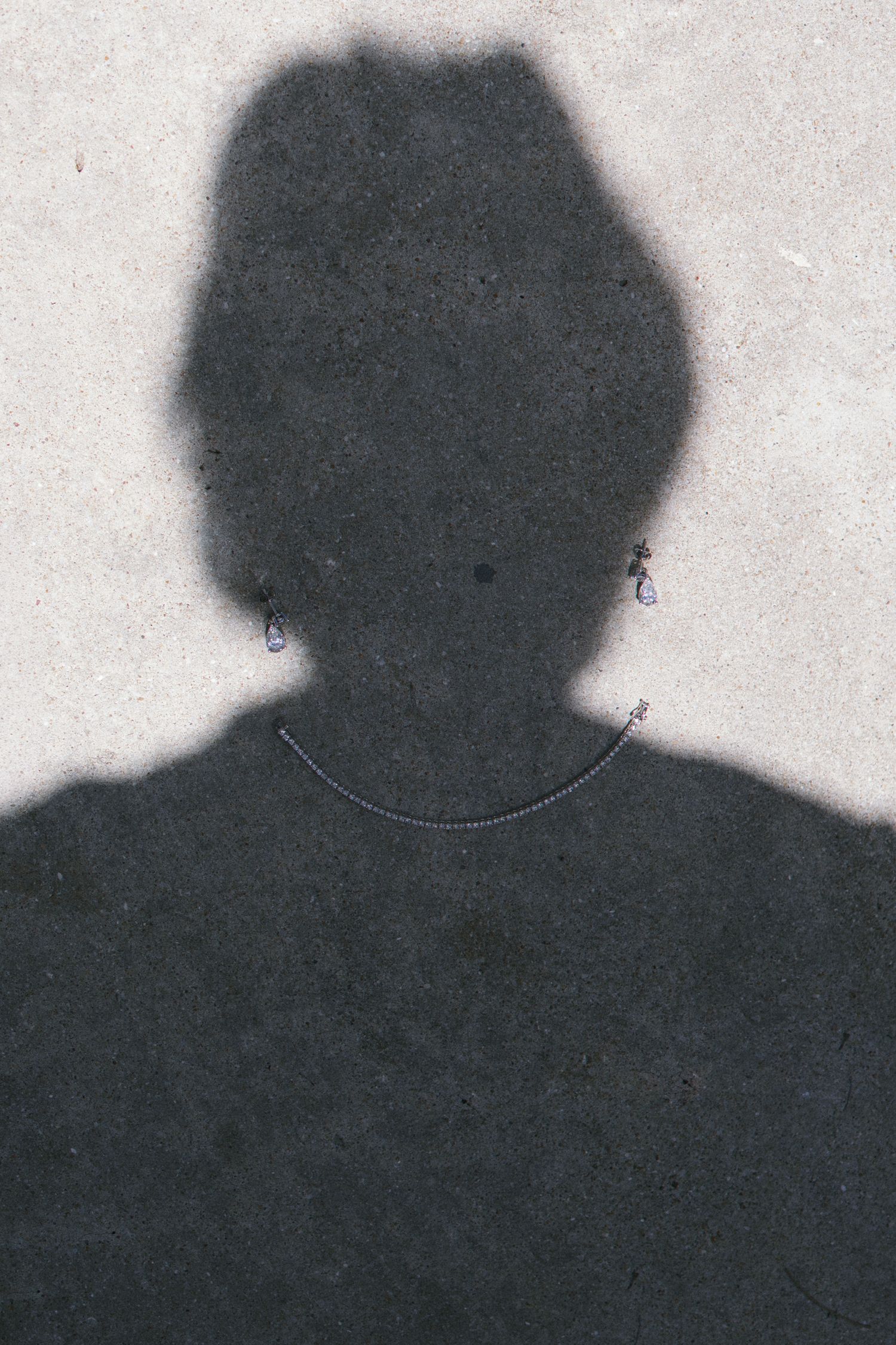 A dark silhouette of a person's head and shoulders against a light gray background.
