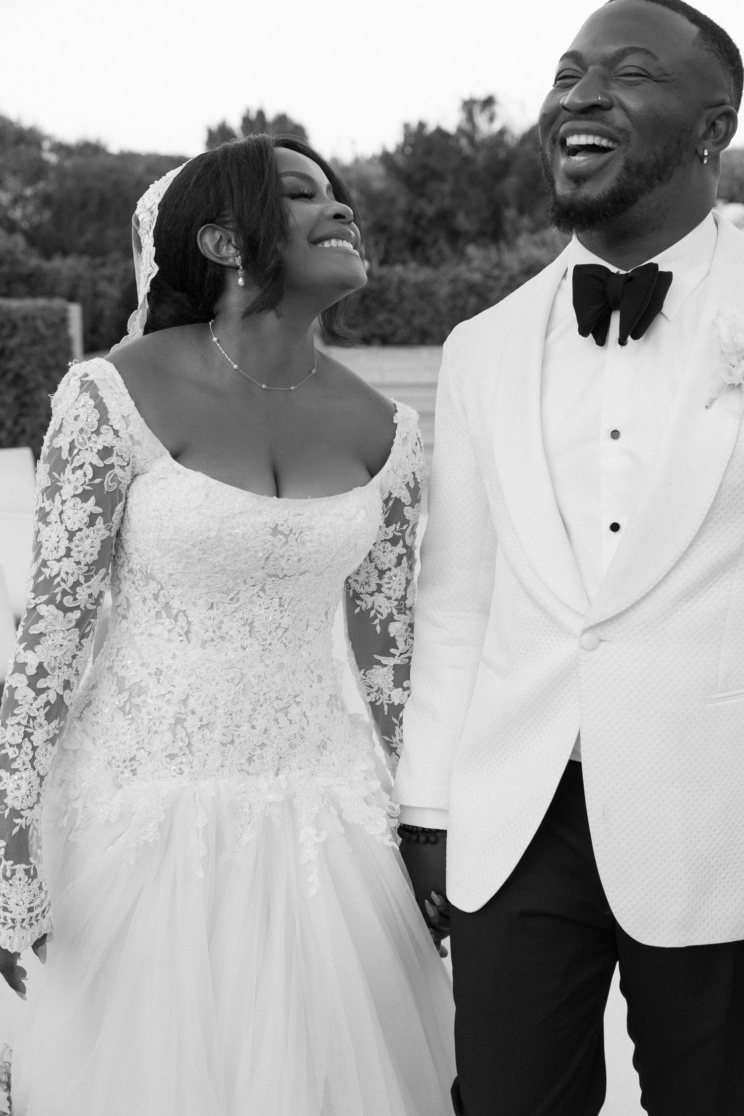 A bride and groom smile and embrace on their wedding day.