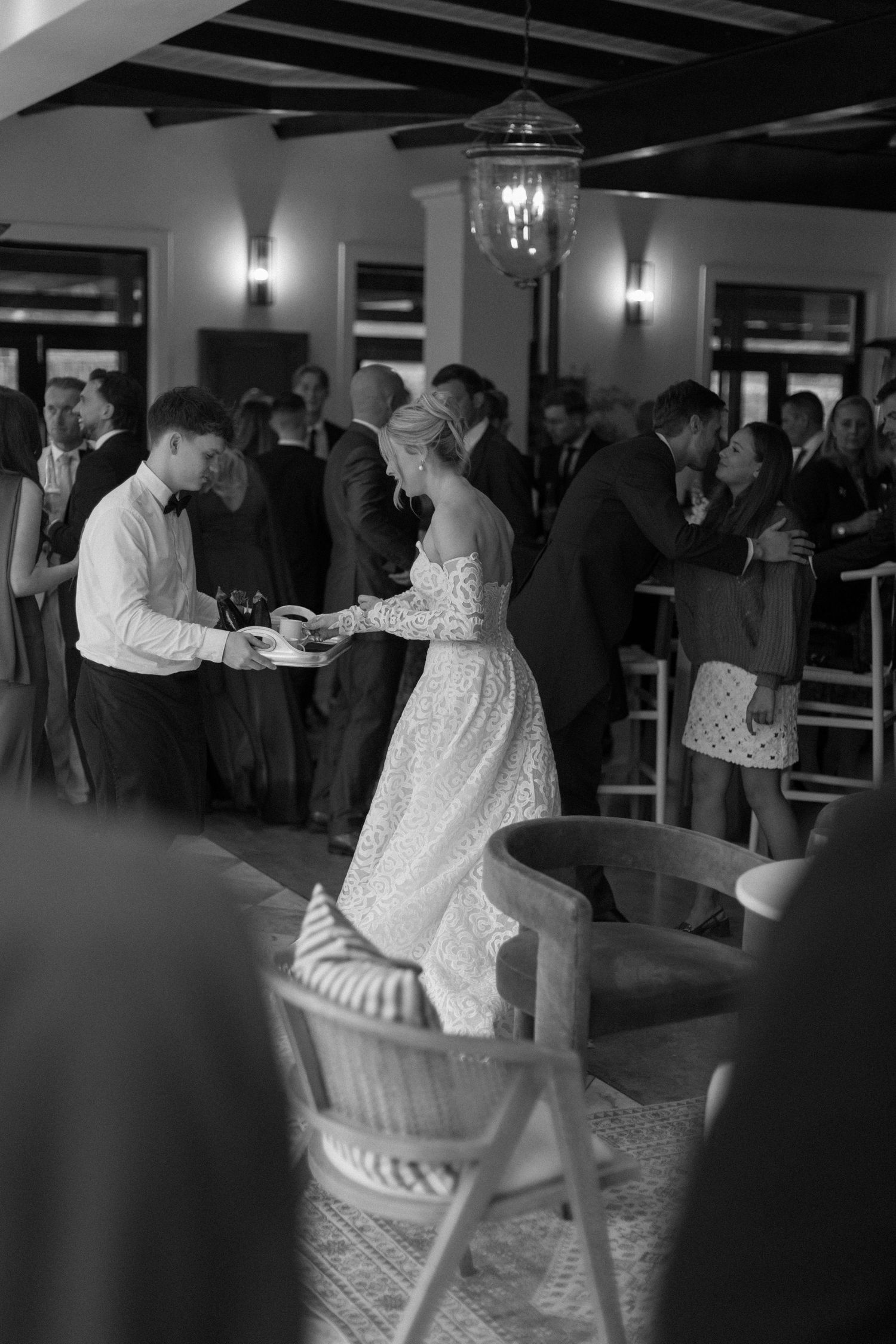 Black and white photos of couples dancing at a social gathering in an indoor venue with exposed beams and wall sconces.