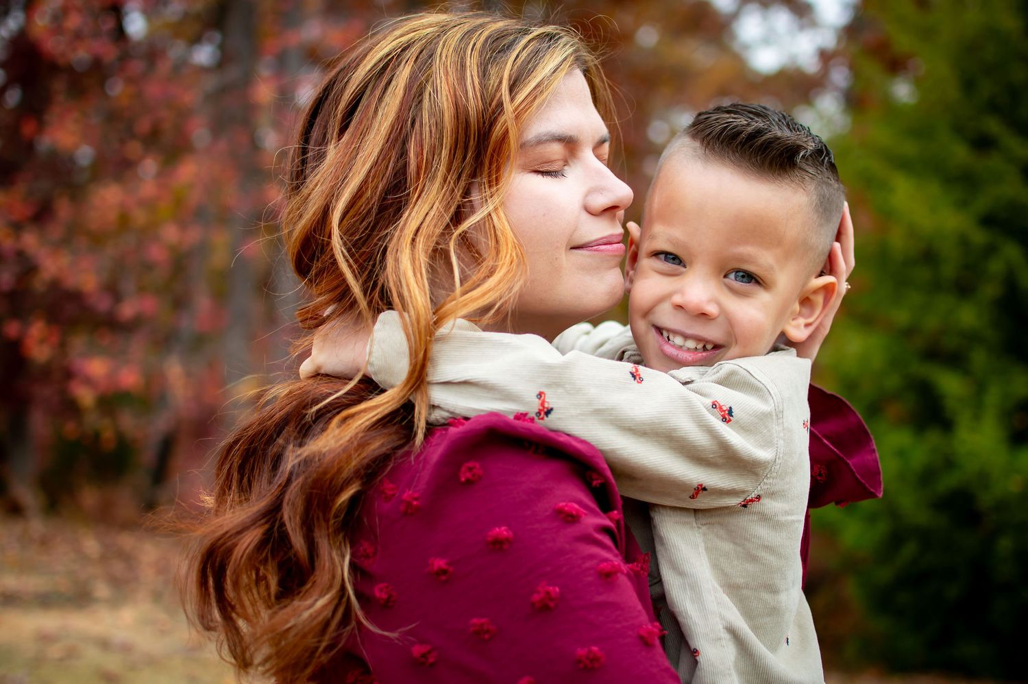Warm embrace captured during autumn with fall foliage in background.