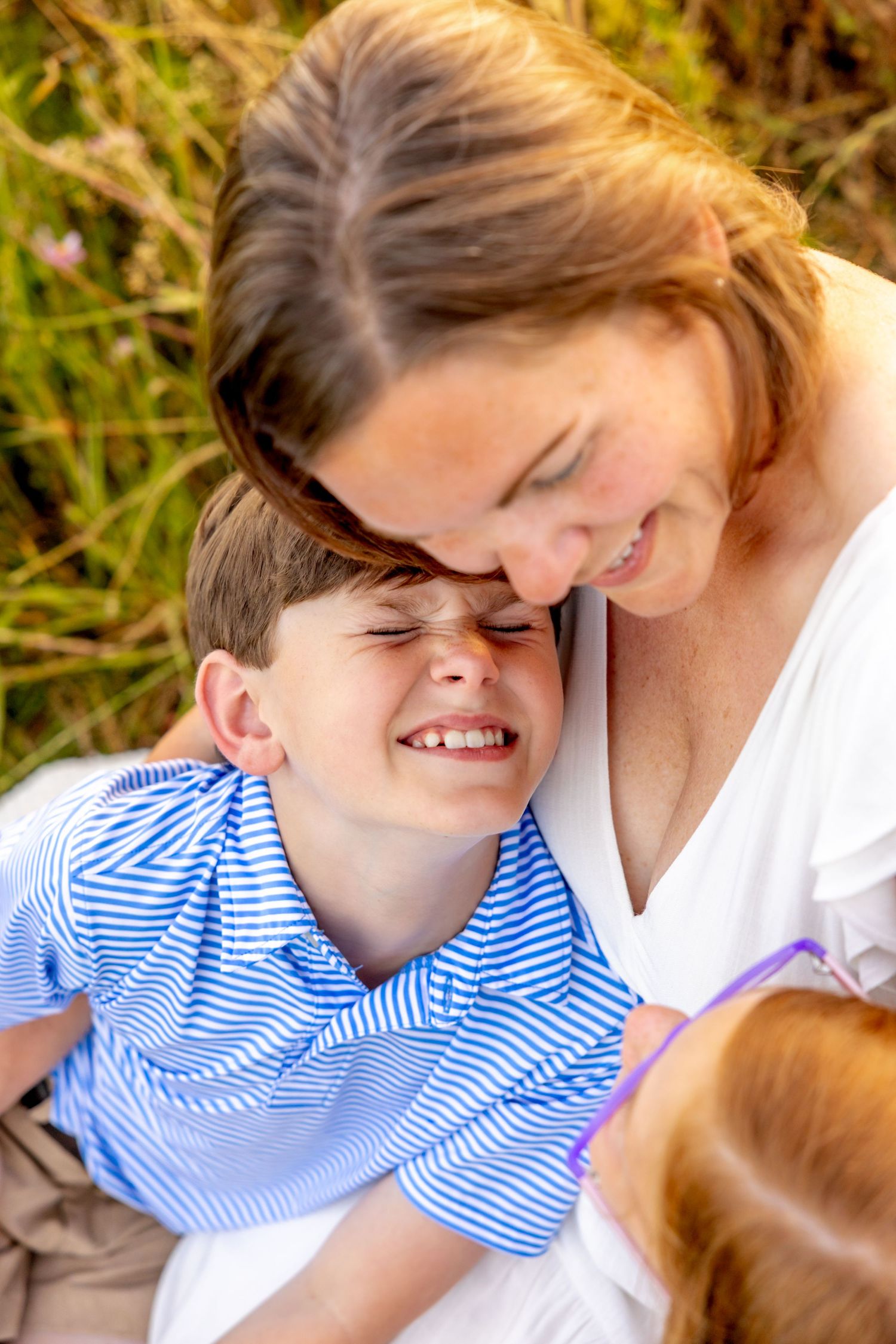 Tender family moments shared during a sunset photo session in tall grass at Blue Hill Garden in Monroe, NC.