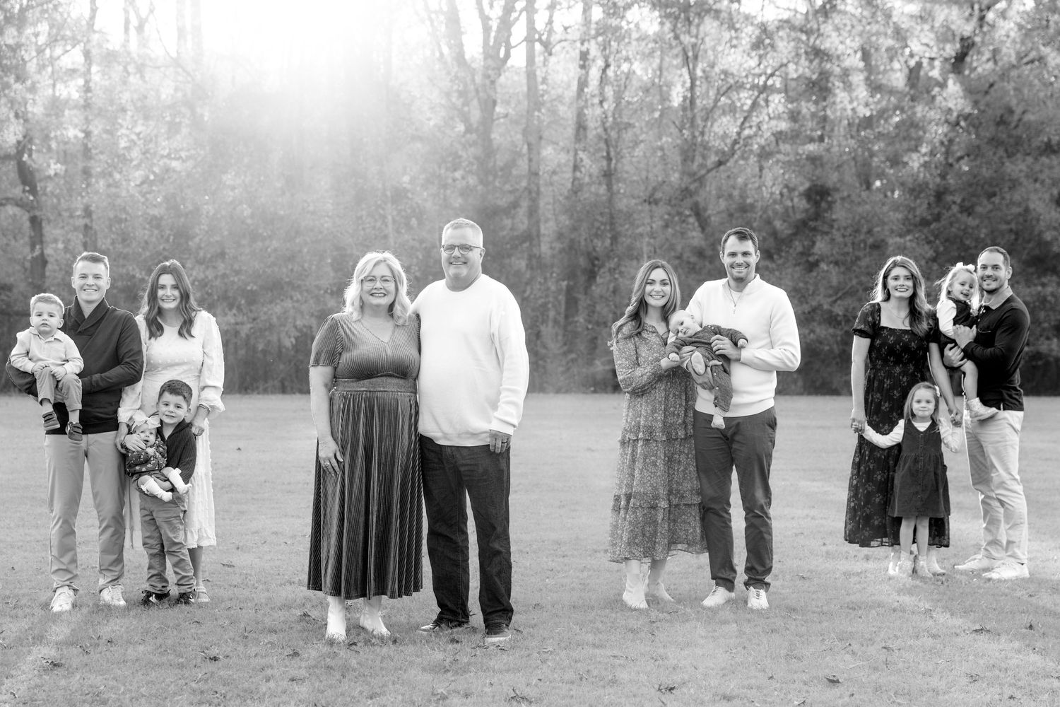 Black and white photo series of family group portraits in a natural outdoor setting.