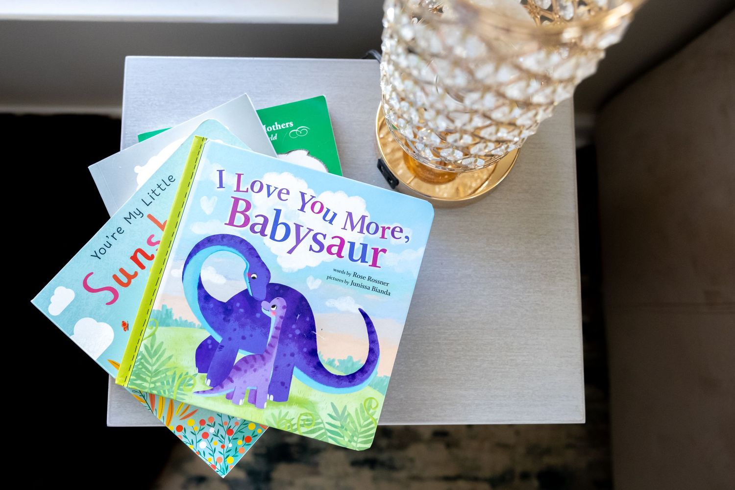 Collection of colorful dinosaur-themed children's books displayed on white surface.