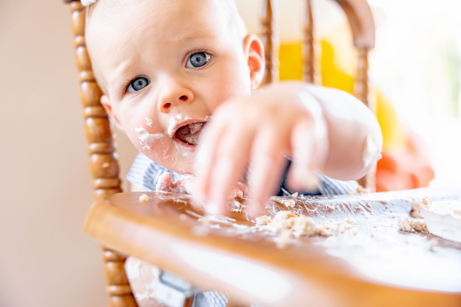 A wooden highchair with water splashing during messy playtime.