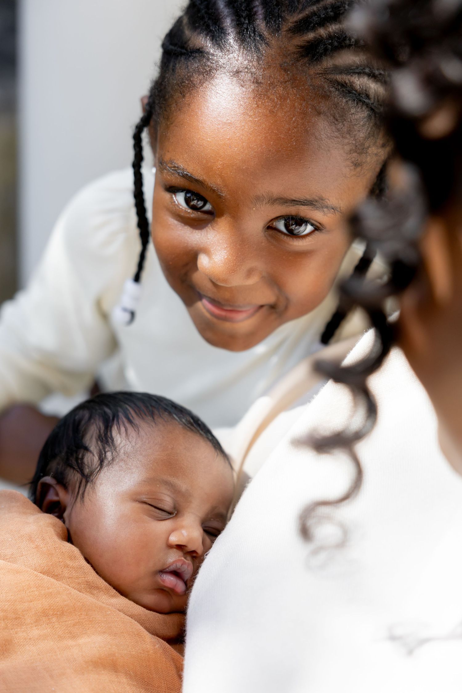 A tender moment captured as a baby sleeps peacefully against someone wearing white.