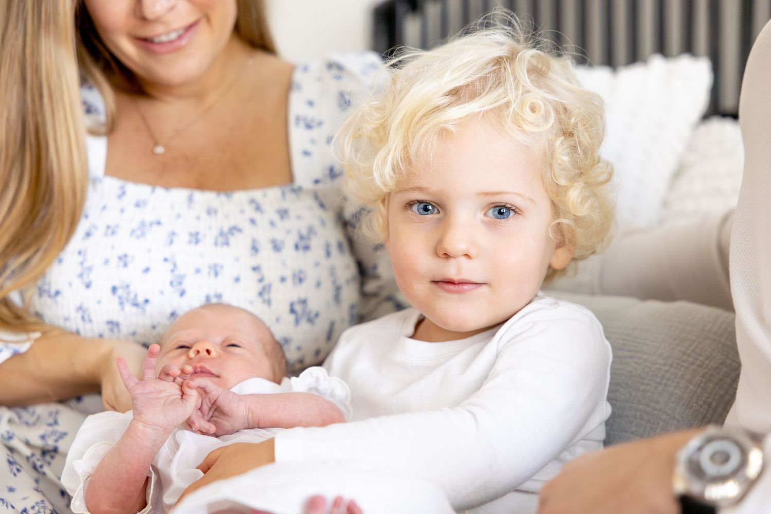 Peaceful indoor family scene with floral dress and white sweater.
