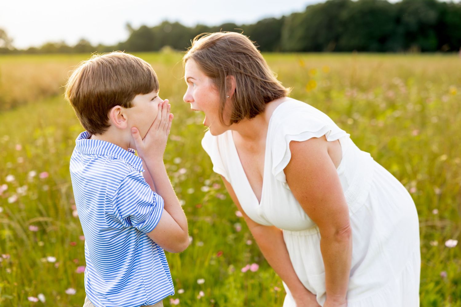 Sweet interaction in a golden flower field at sunset wearing white and blue outfits at Blue Hill Garden in Monroe, NC.