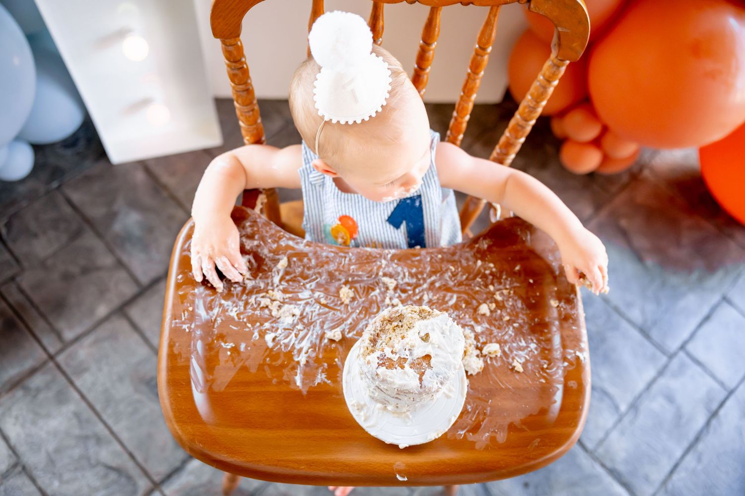 Messy play scene with water splashed across a wooden highchair tray.