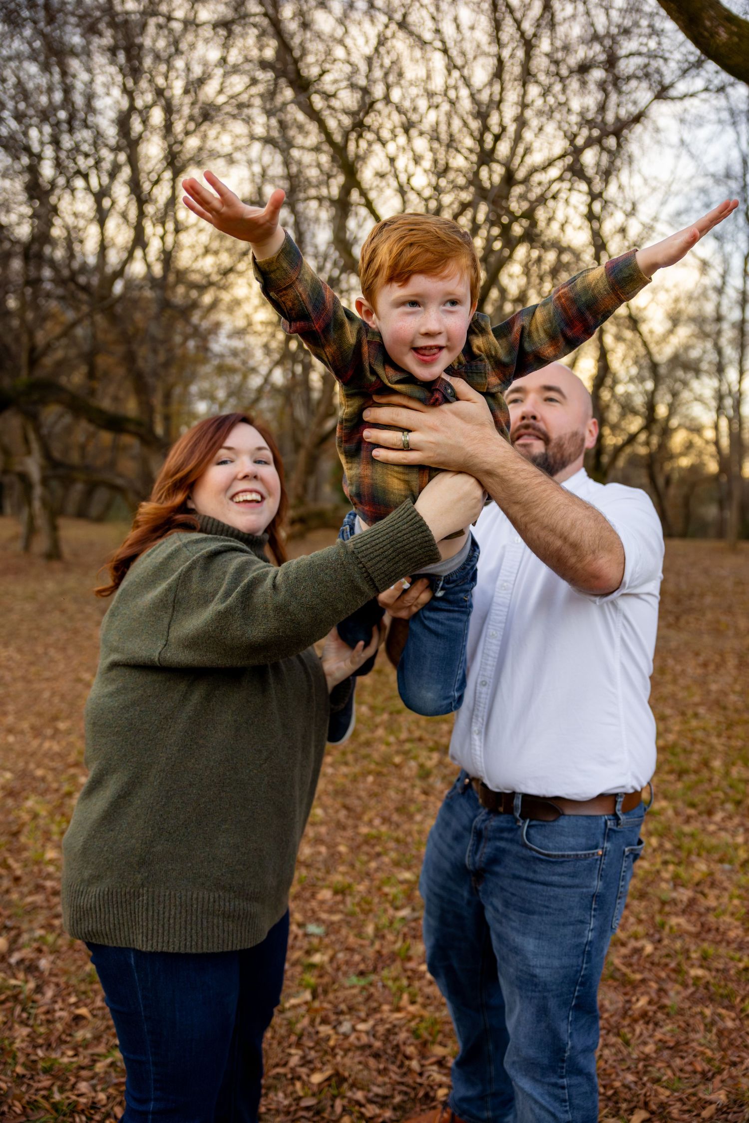 A playful family photoshoot sequence captured in a park setting during fall with autumn leaves on the ground.