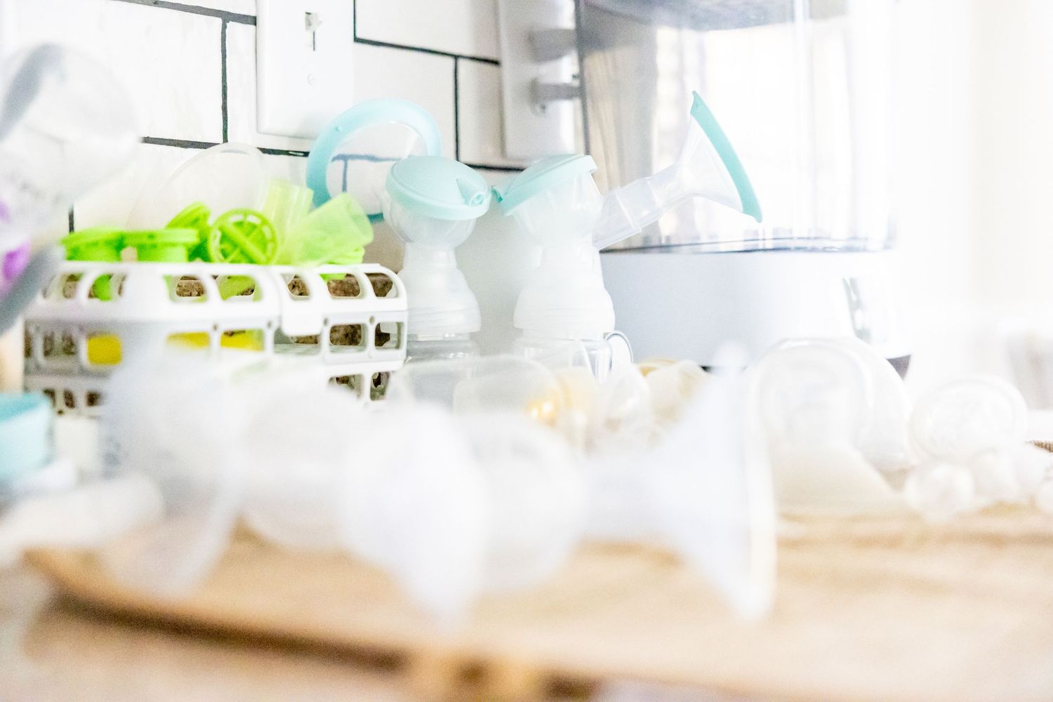 Soft focus decorative items and baby accessories arranged on white surface in natural light.