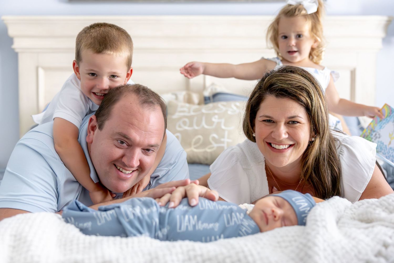 Family members laying together on a bed sharing joyful moments.