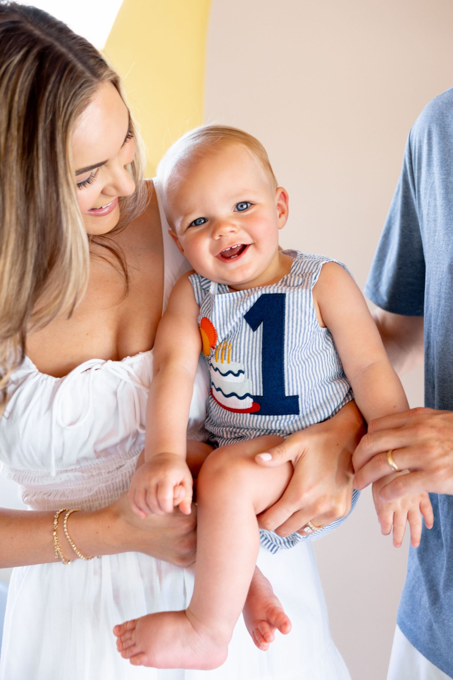 First birthday celebration featuring a baby in blue and white striped clothing.