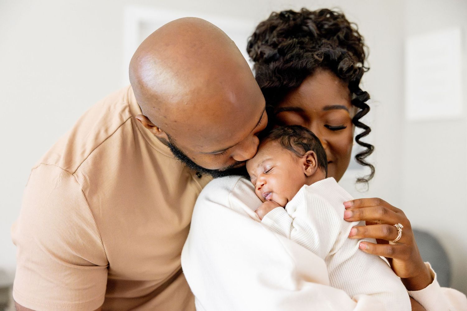 Tender moments photographed in soft natural lighting against neutral backgrounds.