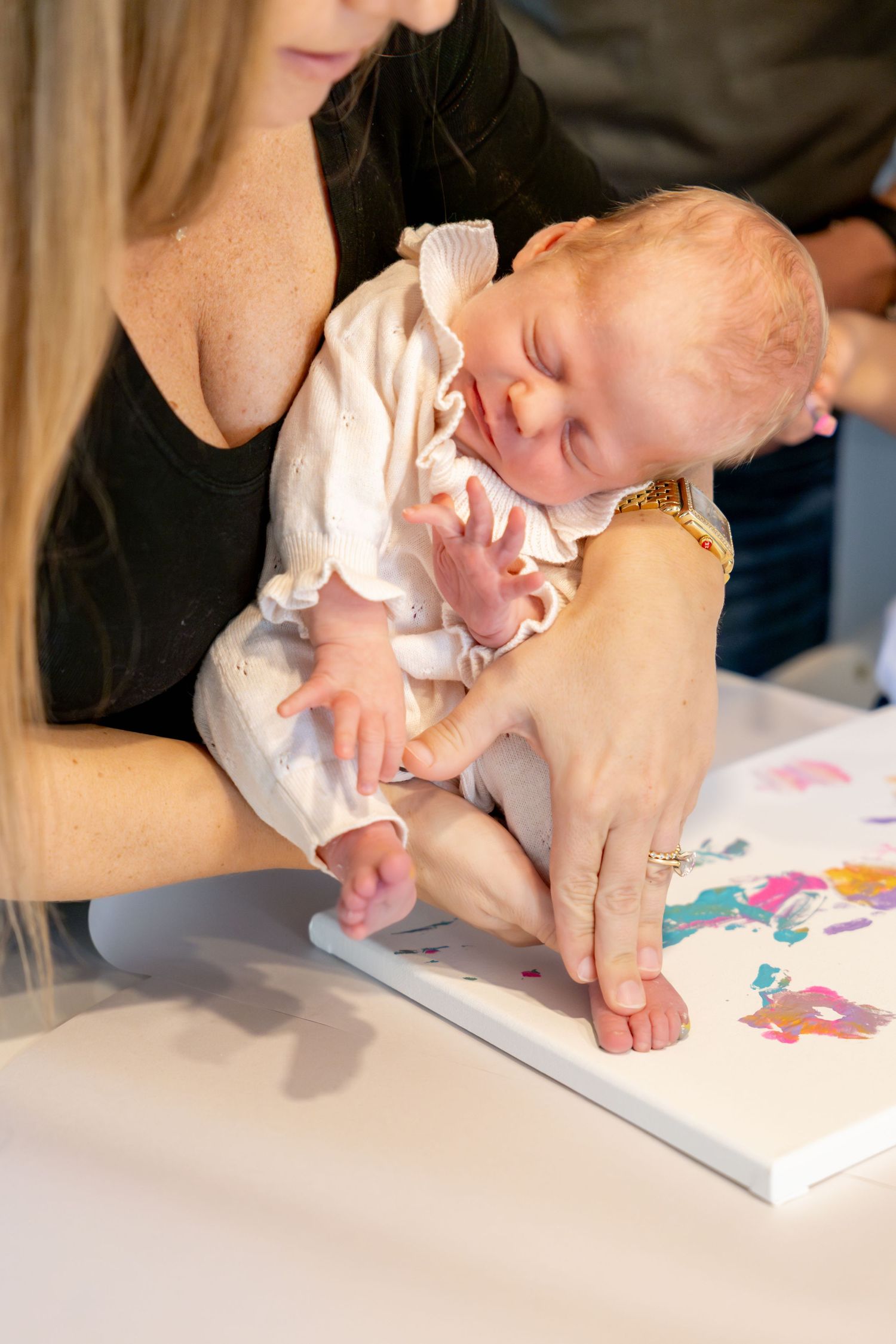 Close-up of hands working on a colorful painting project with finger paints and paper.