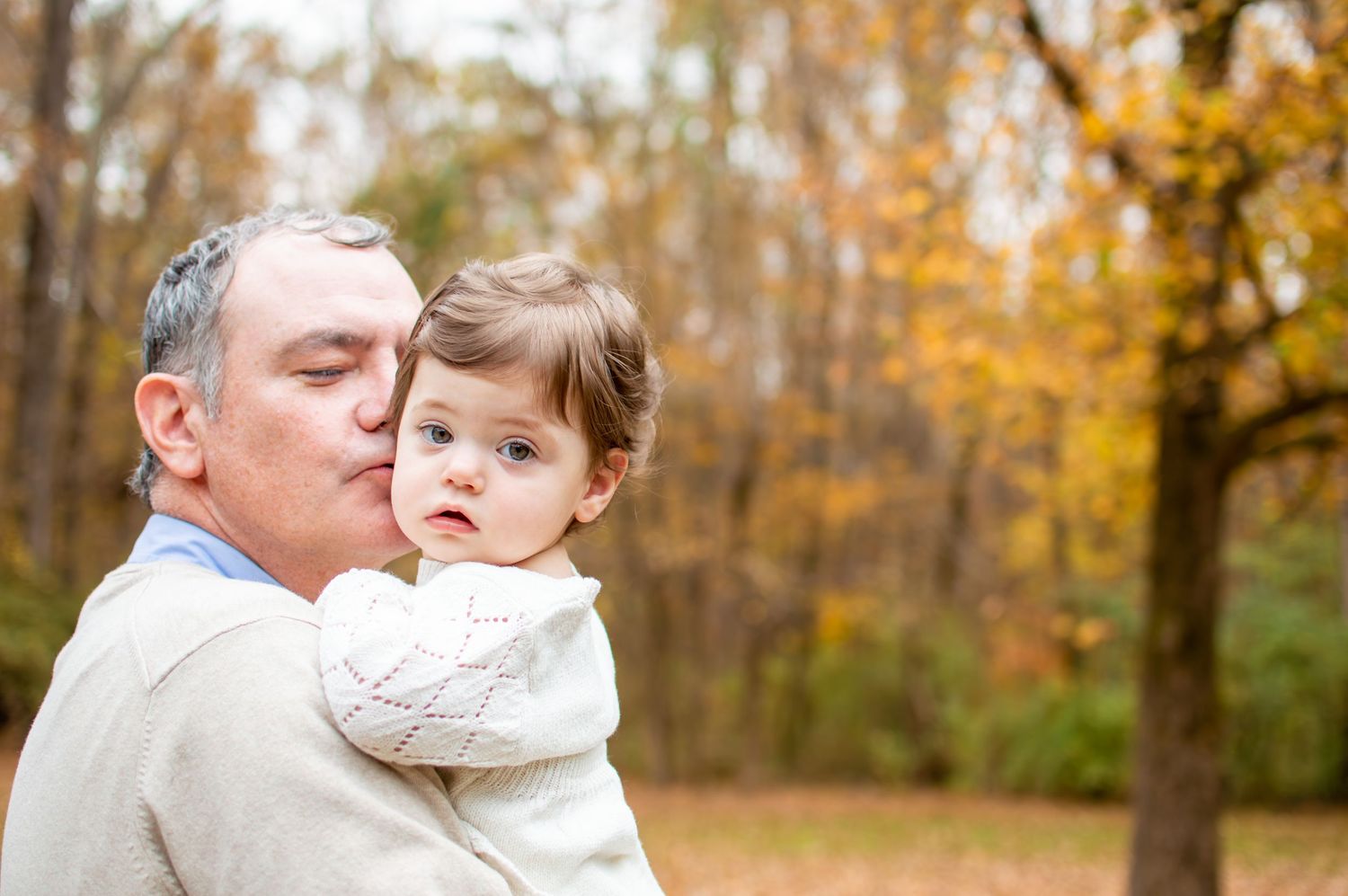 Close up portrait of adult and child against fall foliage background at Westminster Park in Rock Hill, SC.