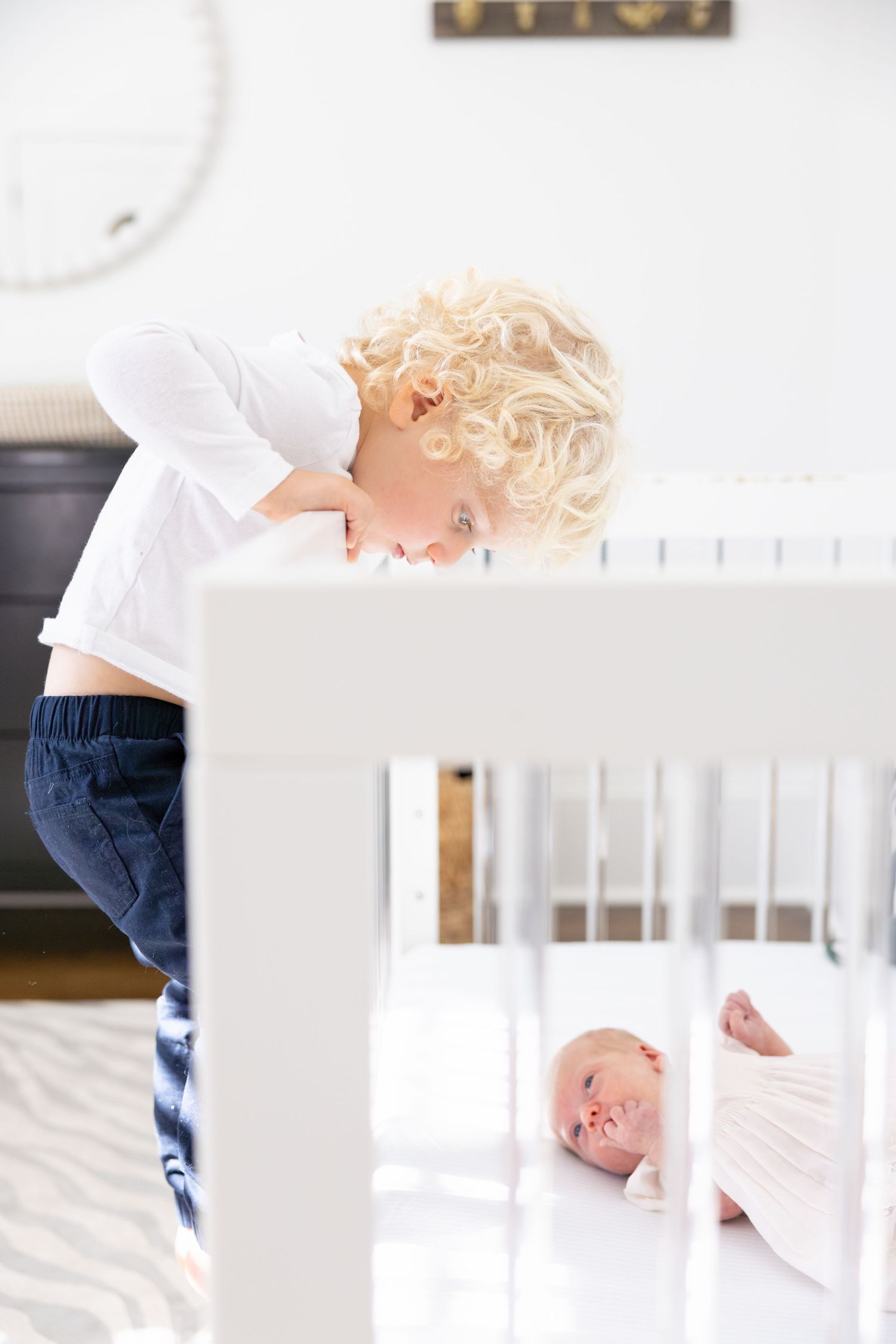 Looking over the side of a white crib in a modern nursery setting.