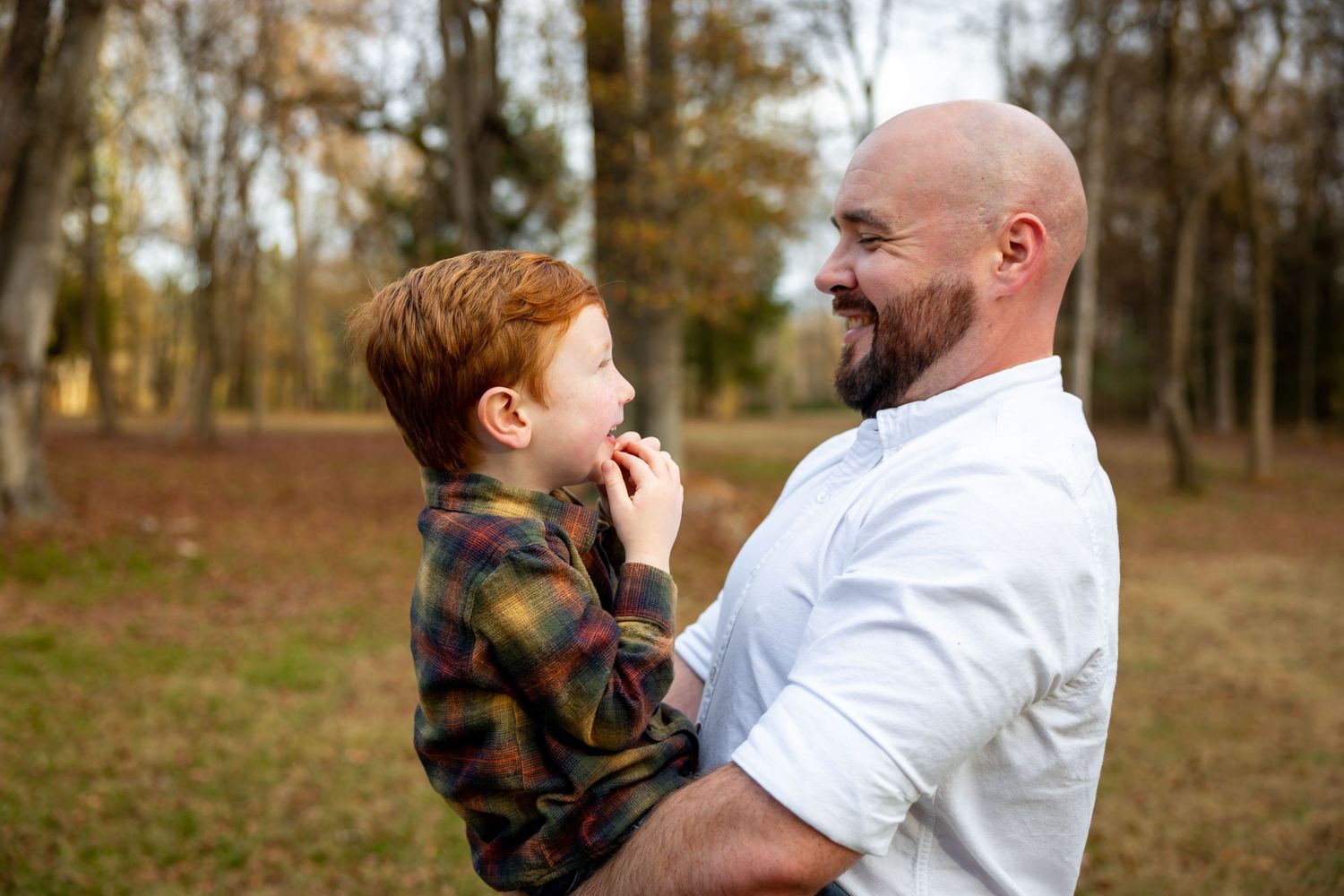 Heartwarming outdoor moment between parent and child in autumn setting.