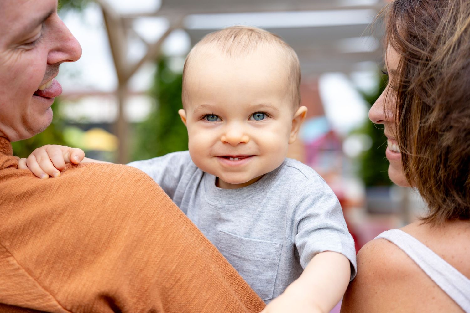 Family sharing tender moments and smiles in outdoor setting at Camp North End in Charlotte, NC.