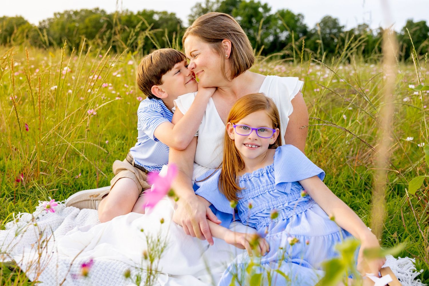 Tender family moment shared while sitting together in a wild flower meadow at sunset at Blue Hill Garden in Monroe, NC.