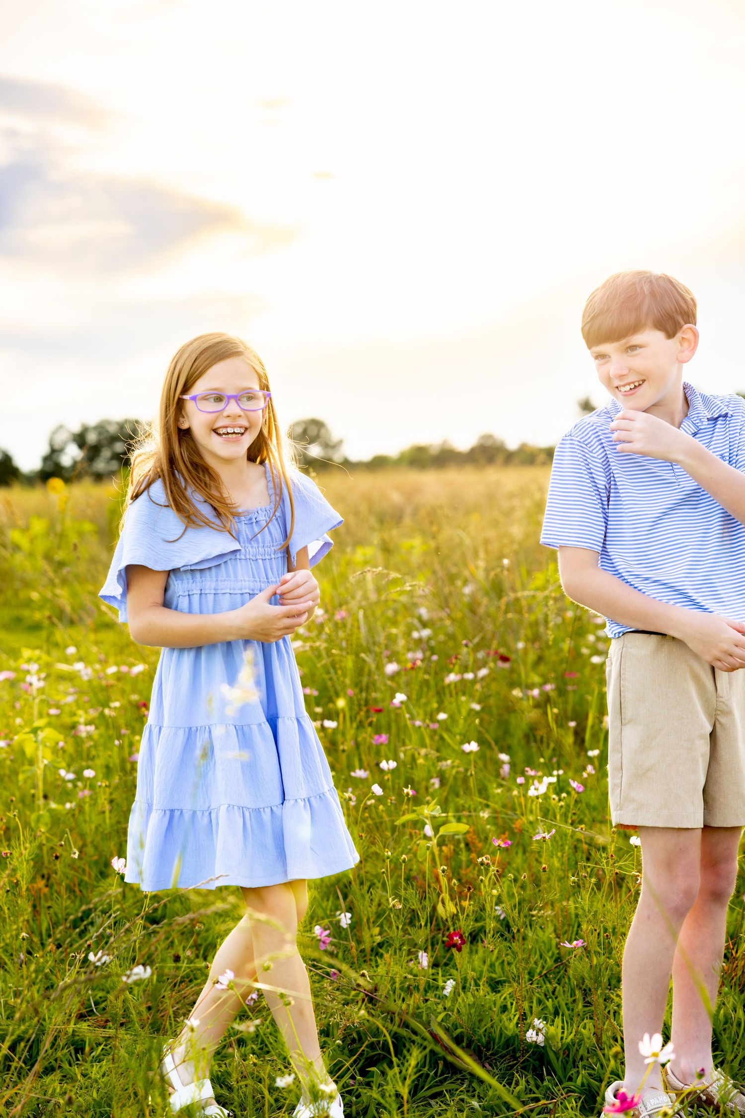 Playful poses in a summer meadow wearing coordinated blue outfits among wildflowers at Blue Hill Garden in Monroe, NC.