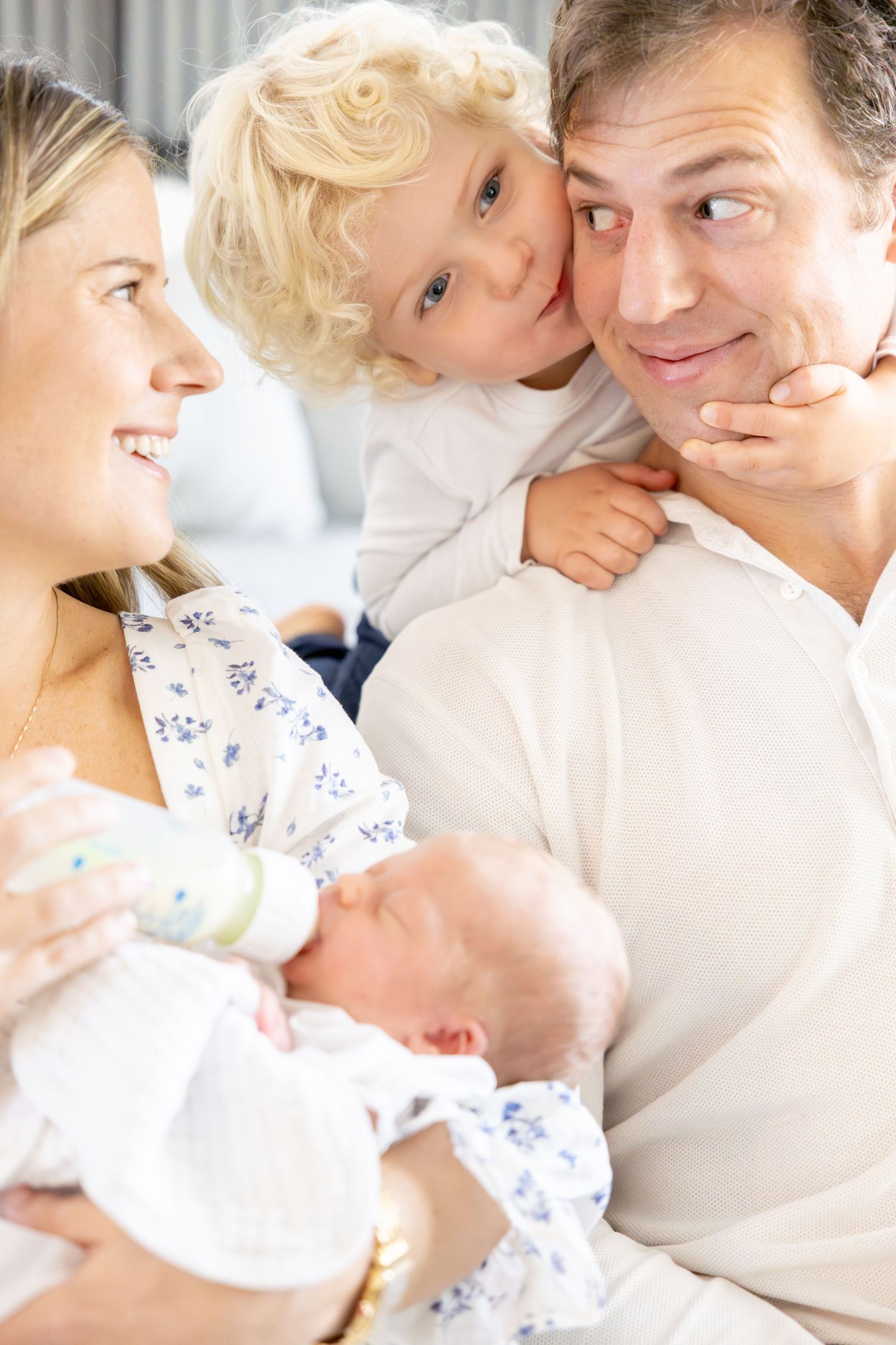 Sweet family moment as they cuddle together with their newborn baby on a bright morning.