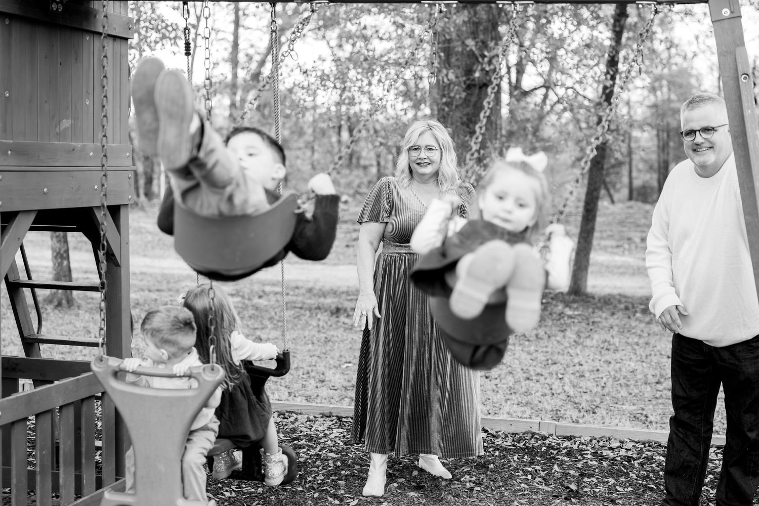 Energetic child swings on playground equipment in a dynamic black and white photo series.