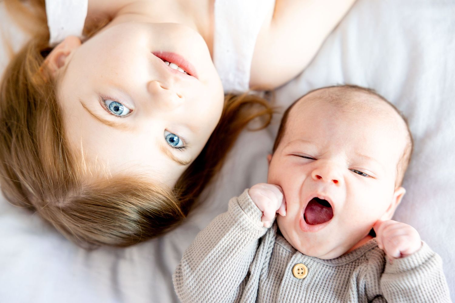 A playful sequence of intimate family moments captured on white bedding.