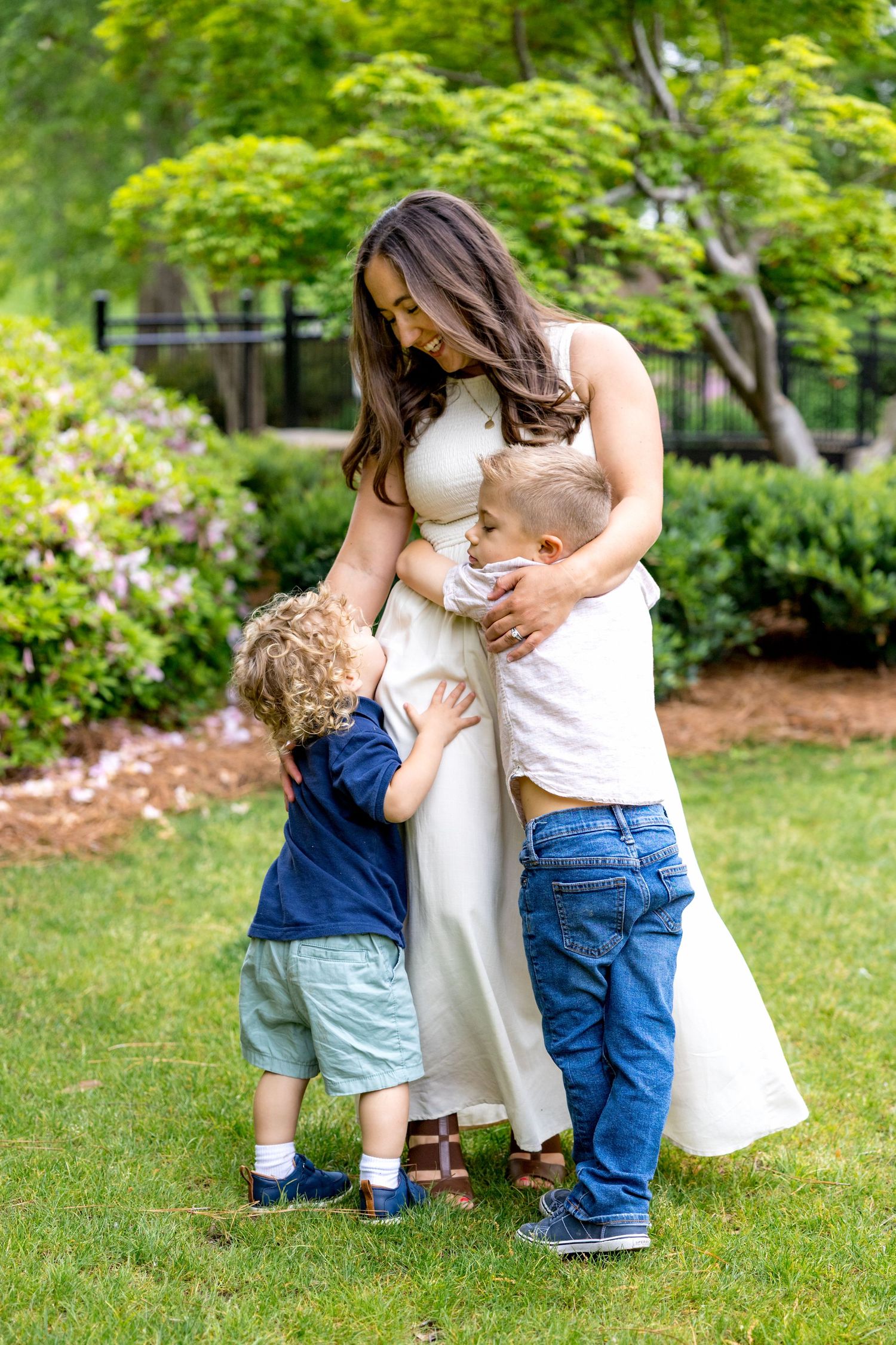 Sweet family interaction in a garden with blooming flowers and greenery.