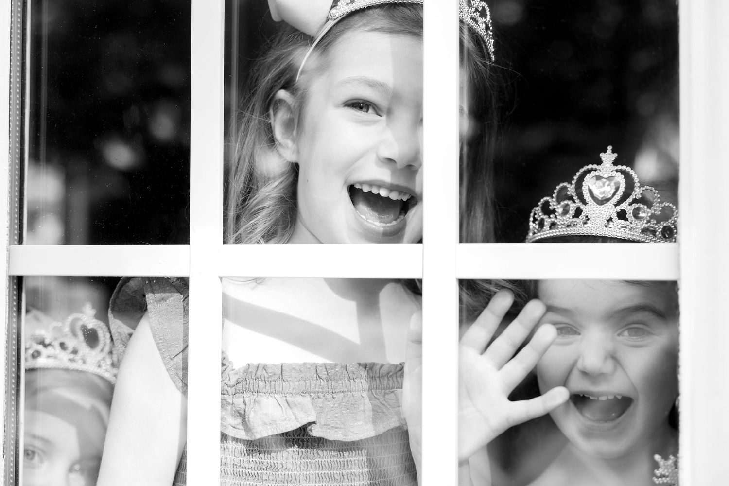 Collection of joyful expressions captured through window panes in black and white.