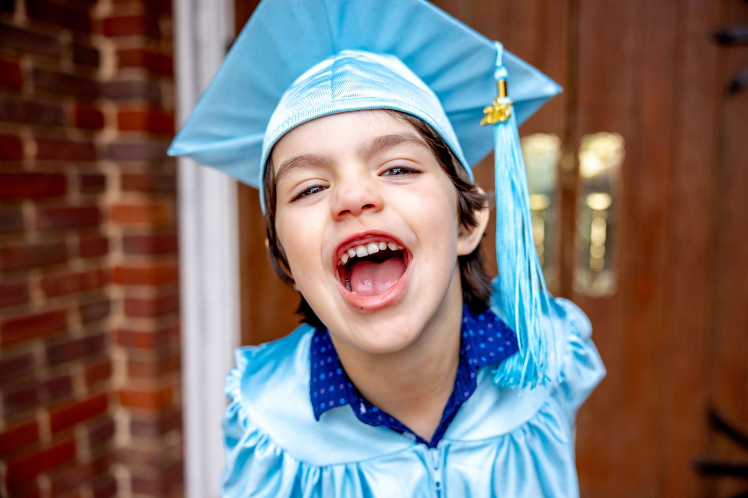 Progressive shots showing excitement while wearing a light blue preschool graduation outfit.