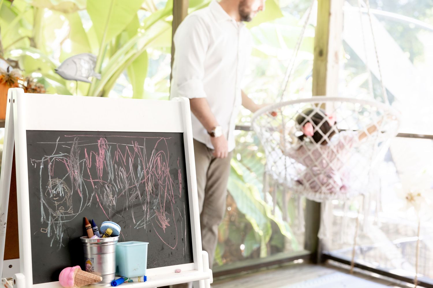 Chalkboard and art supplies in bright sunlit room with lattice wall.
