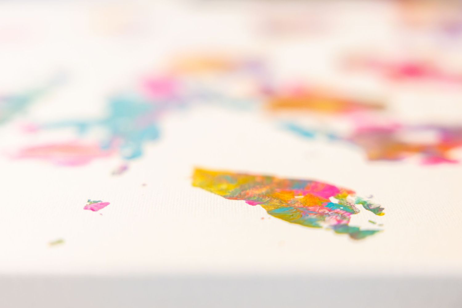 Abstract colorful finger paint artwork with bright blues, pinks, and yellows on white paper.