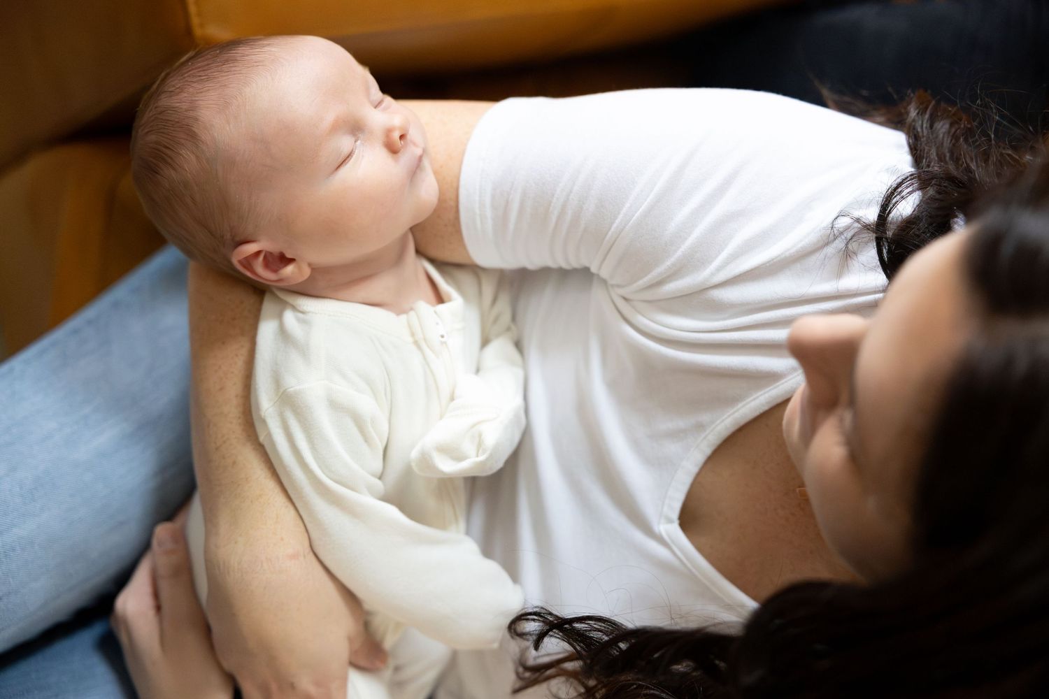 Infant being cradled while wearing white clothing.