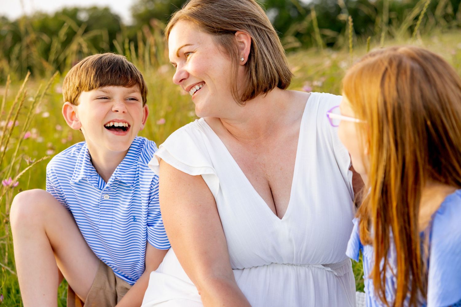 Natural candid moment of shared laughter in a summer wildflower field at Blue Hill Garden in Monroe, NC.