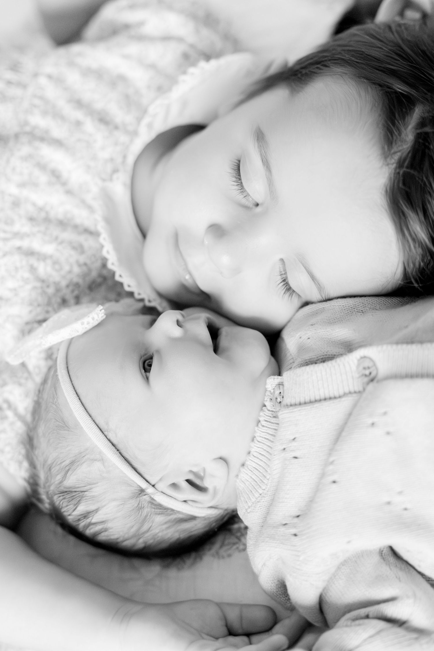 Black and white portraits of a sleeping baby in soft cotton clothing.