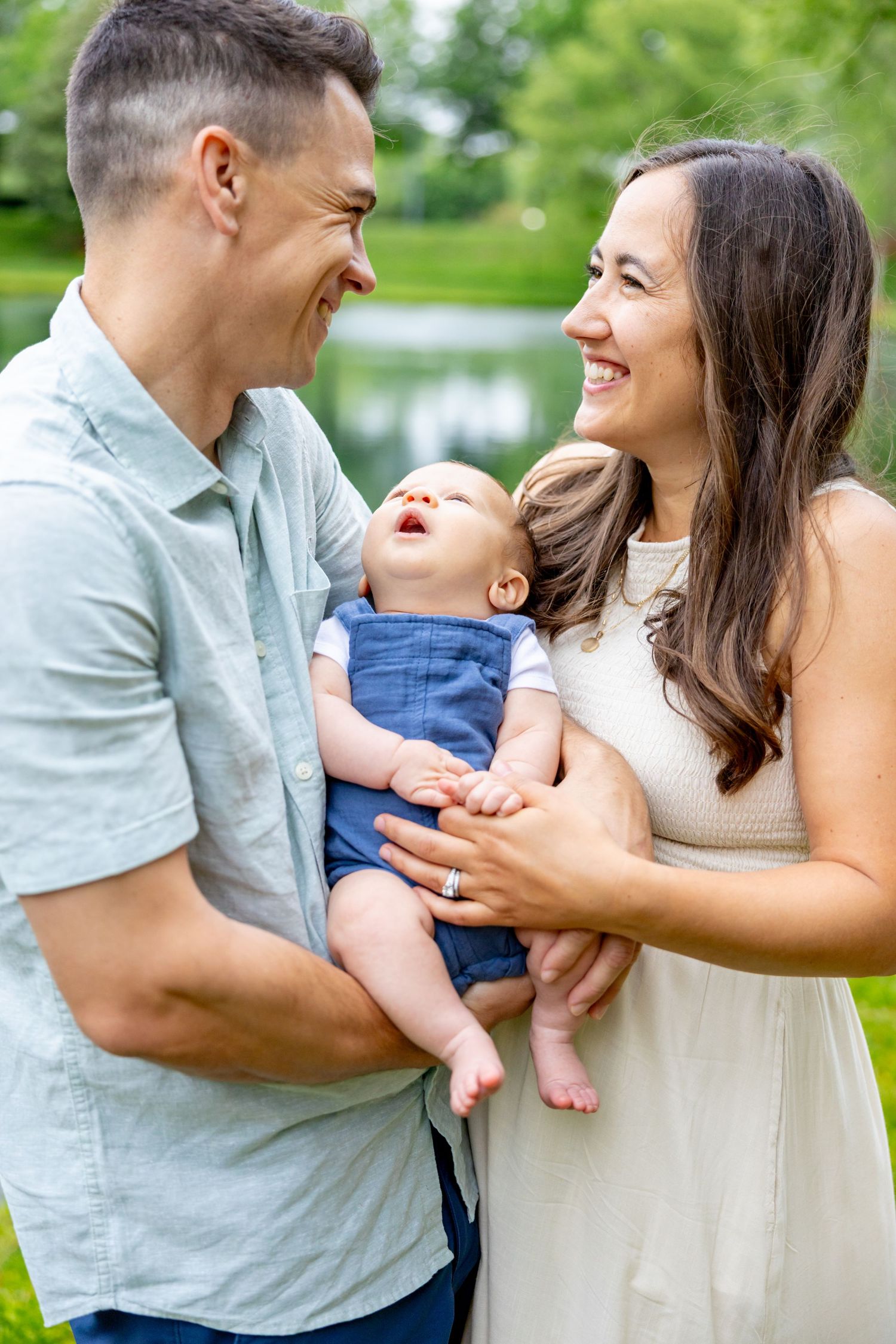 Joyful family moment filled with laughter in a sunny park setting.