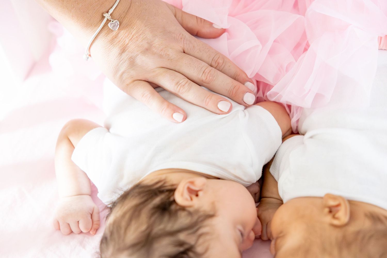 Soft pink tones highlight tender family moments during an indoor photo session.