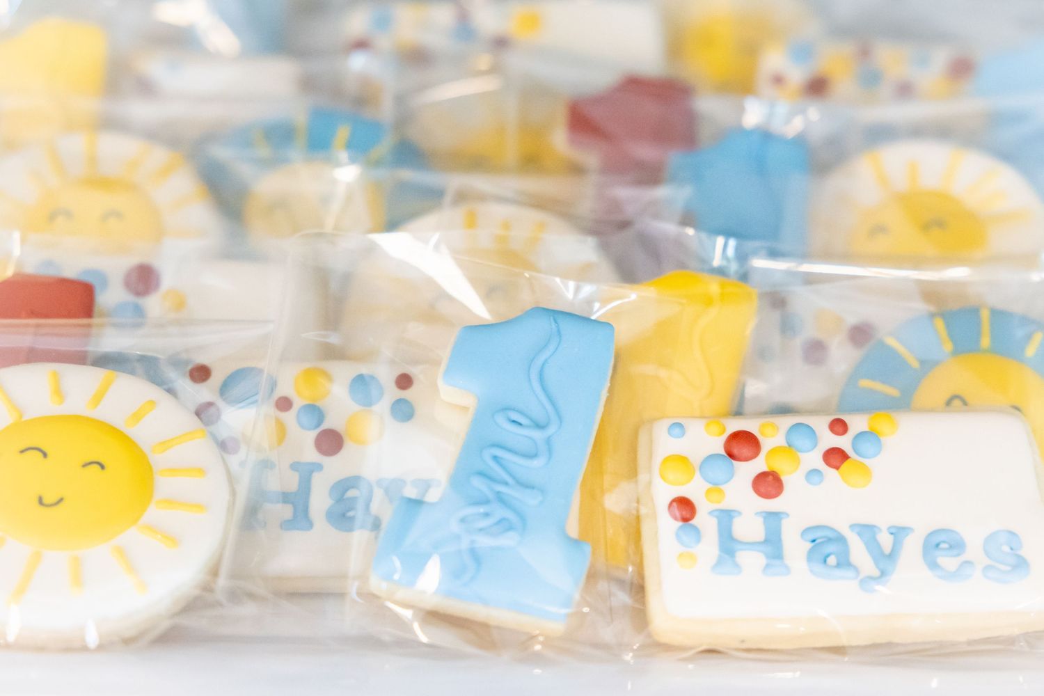 Whimsical pastel blue and yellow decorated sugar cookies with happy sun designs.