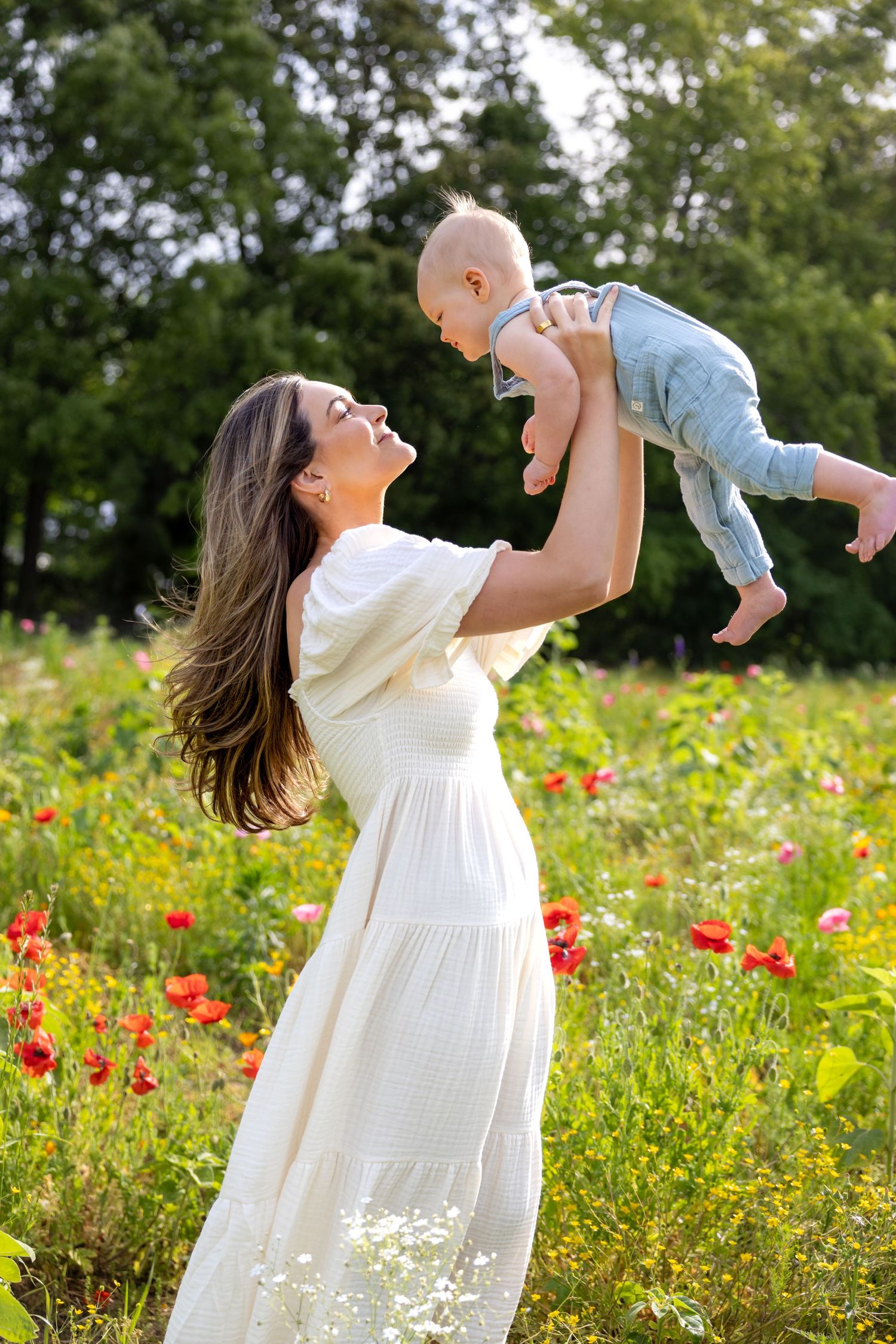 Playful moment in a field of red poppies and wildflowers on a bright summer day at Blue Hill Garden in Monroe, NC.