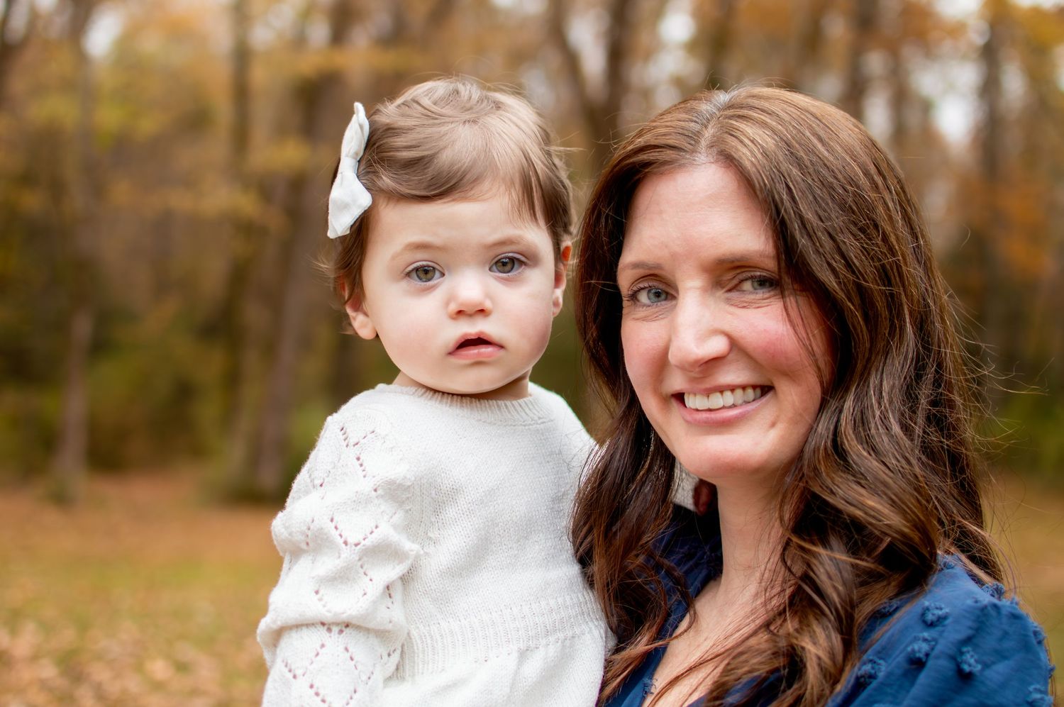 Portrait of two people smiling at camera with autumn trees in background at Westminster Park in Rock Hill, SC.