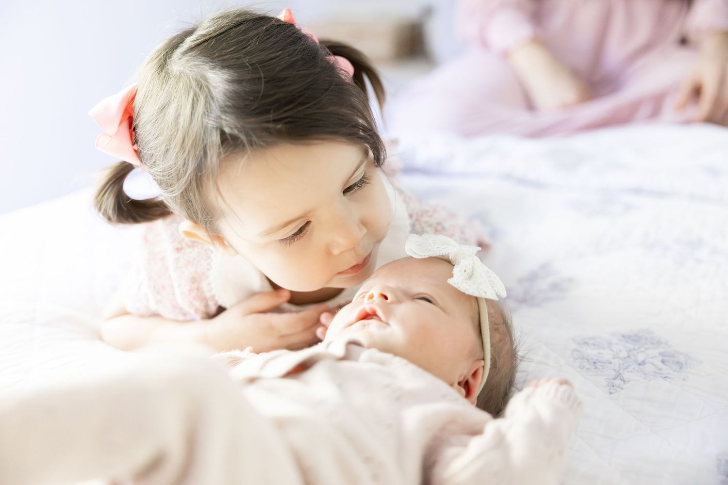 Sweet candid moments captured on white bedding in natural light.