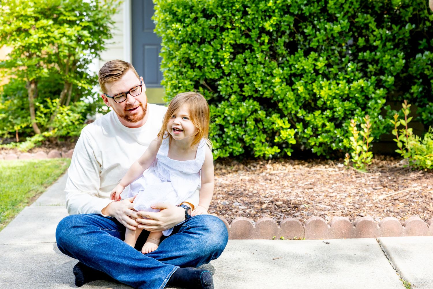 Family sharing a joyful moment together while sitting on the ground outdoors.