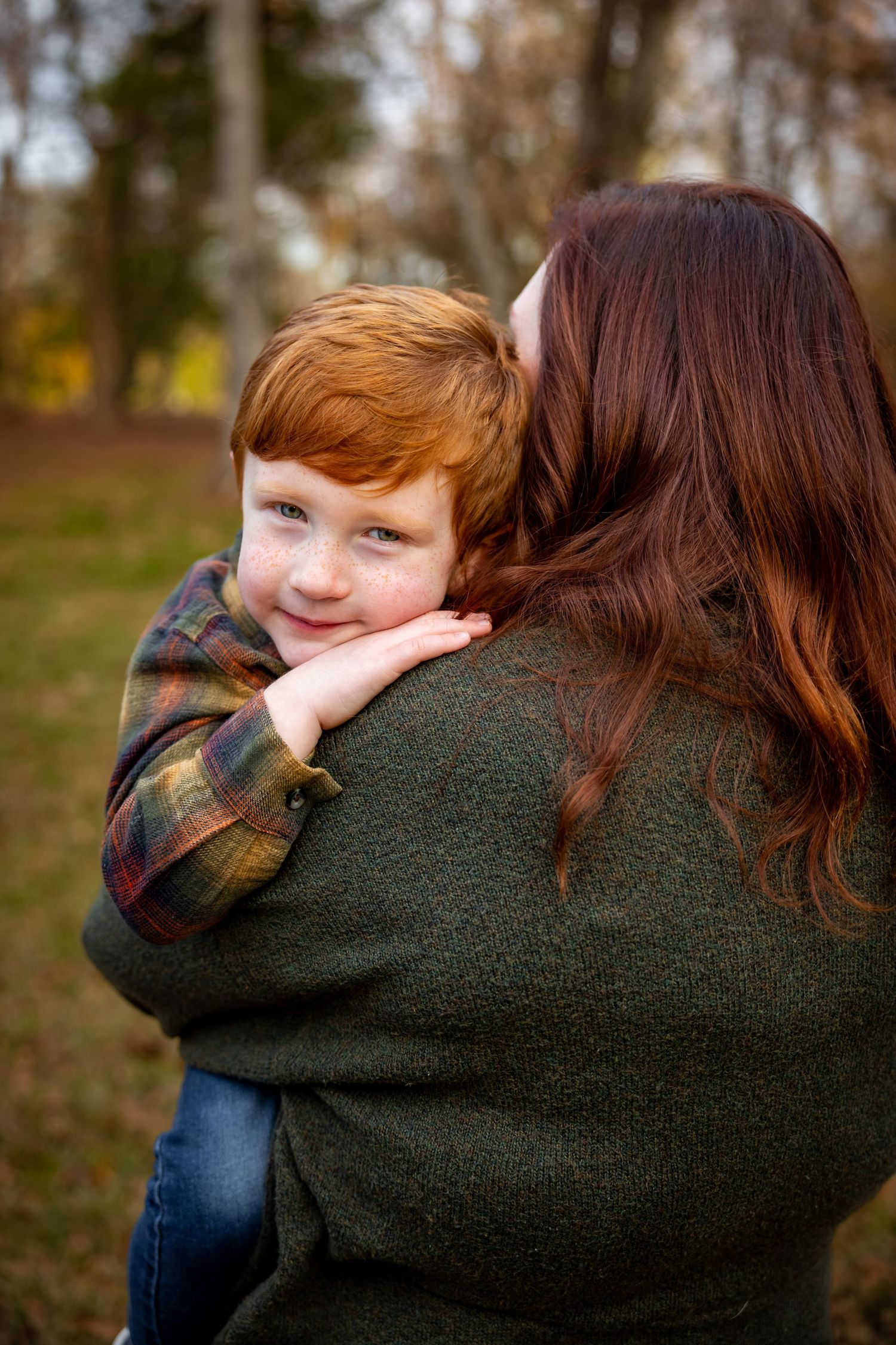 Tender moment captured between parent and child during an autumn outdoor photoshoot.
