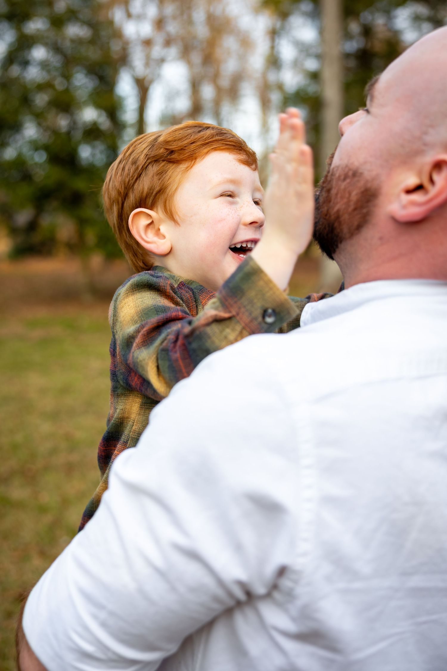 Candid moment of laughter between parent and child outdoors.
