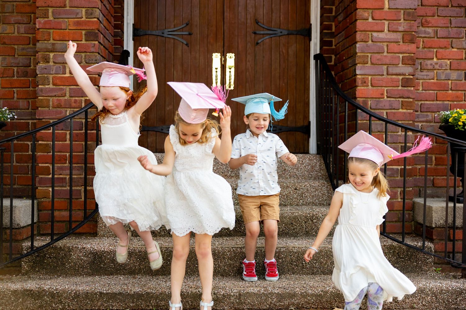 Playful preschool graduation photo sequence of children jumping off of brick church steps.