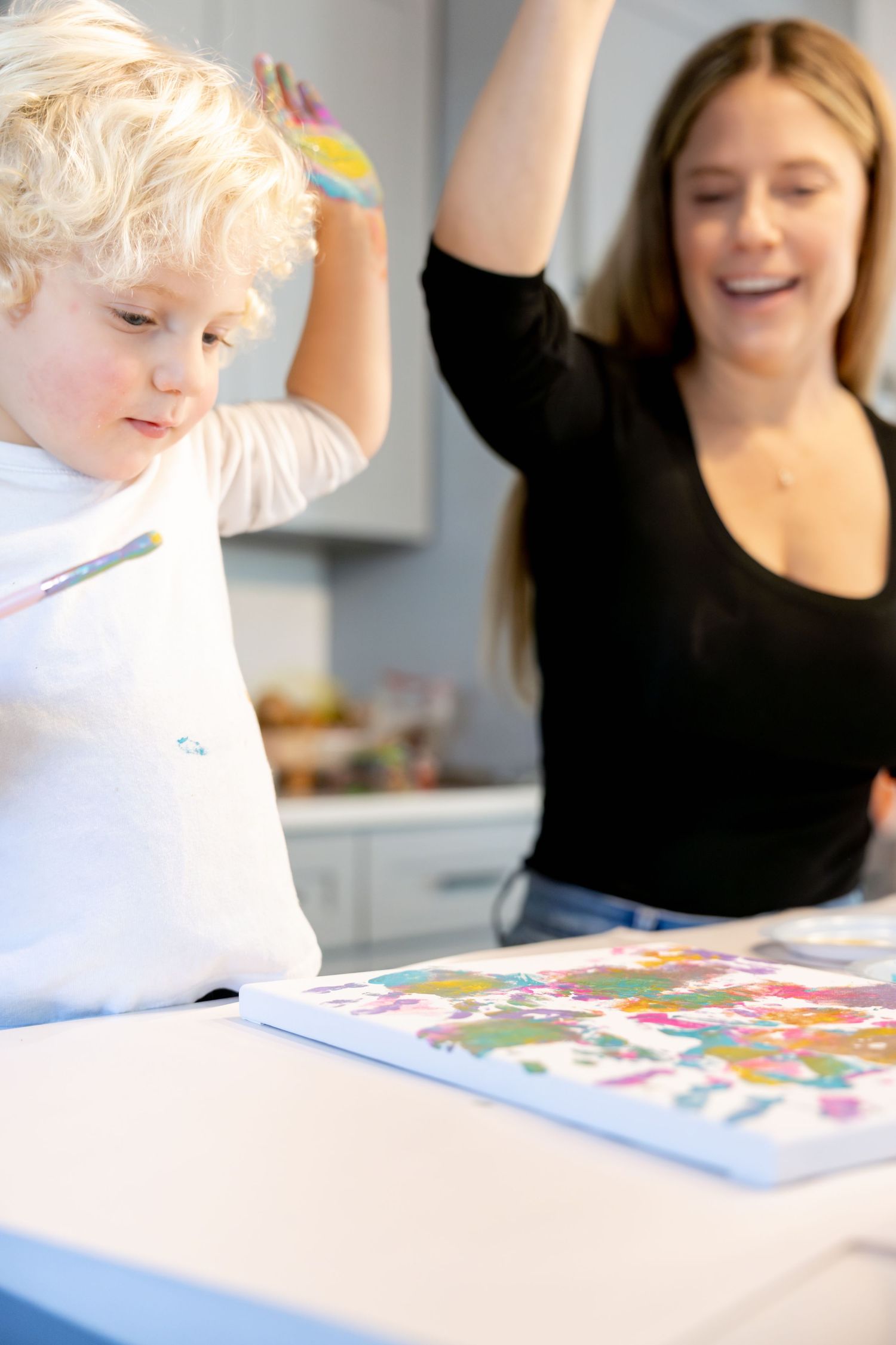 Playful art session showing movement and joy while creating colorful finger paintings.