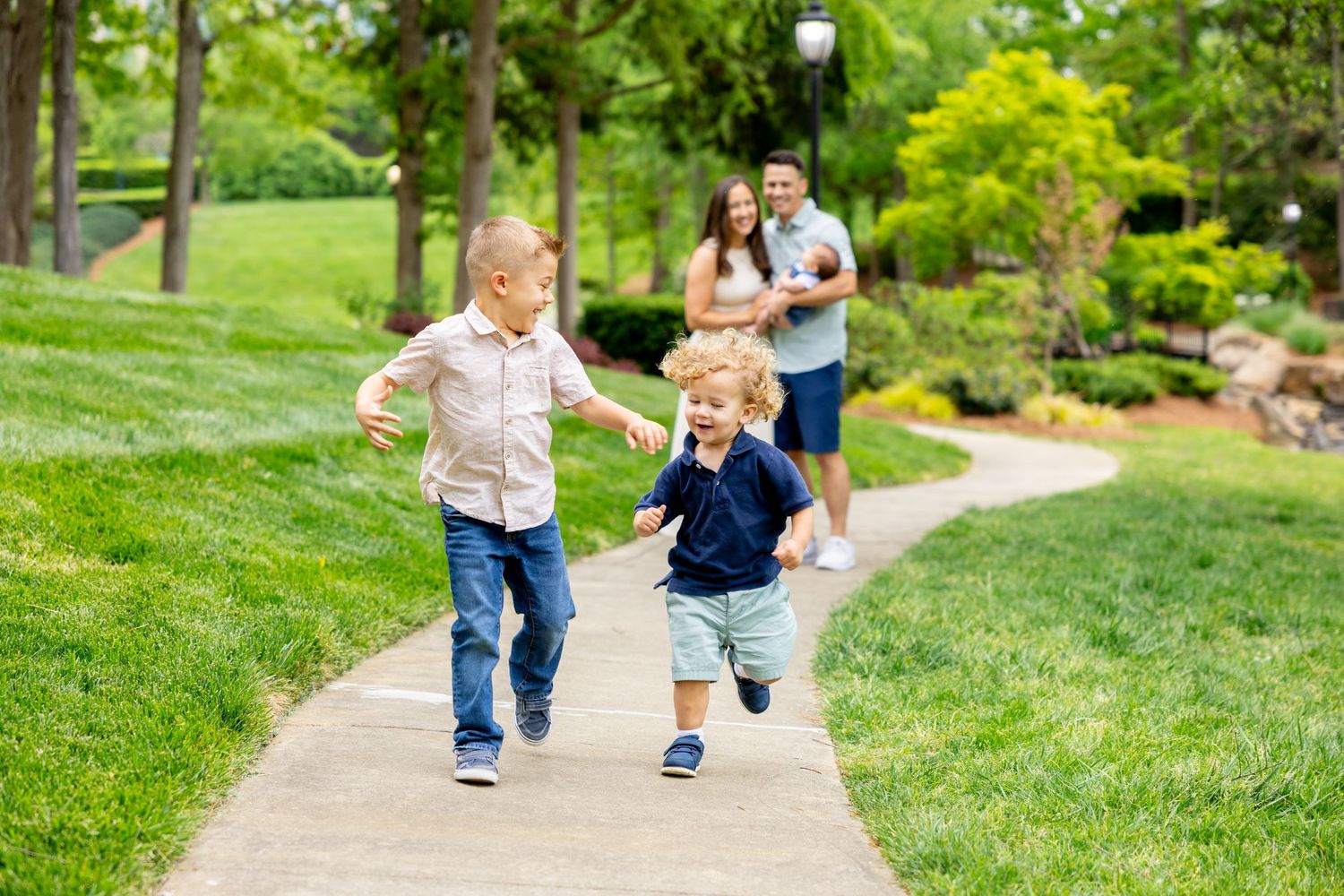 People walking together on a winding garden path through lush green landscaping.