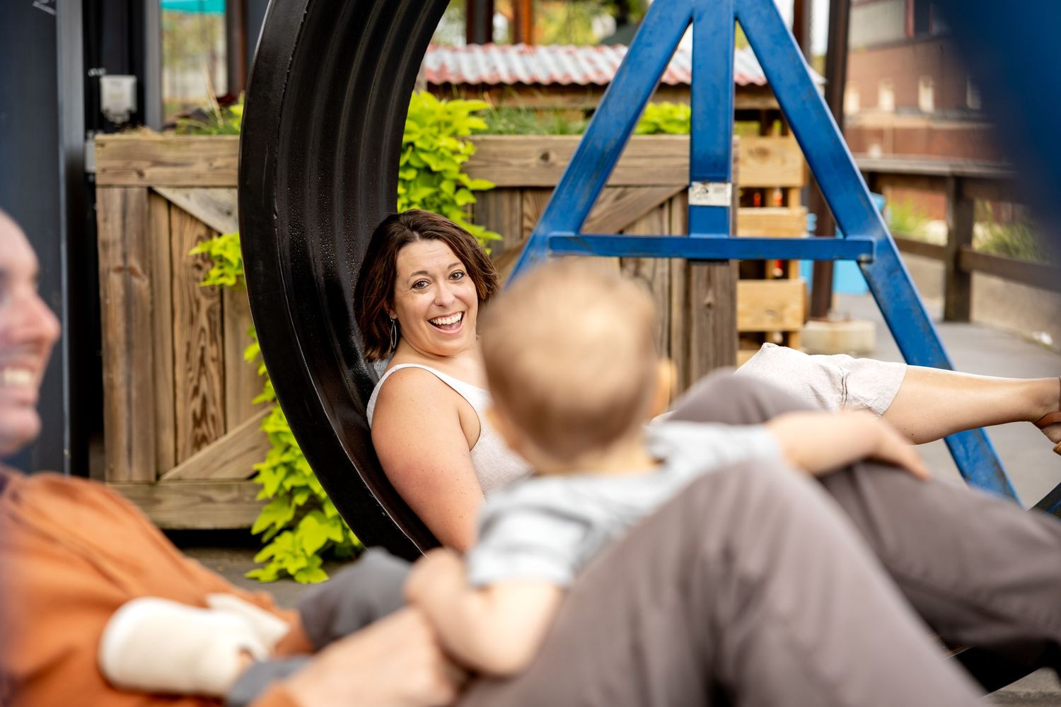 Playful interactions between family members on unique seating at Camp North End in Charlotte, NC.