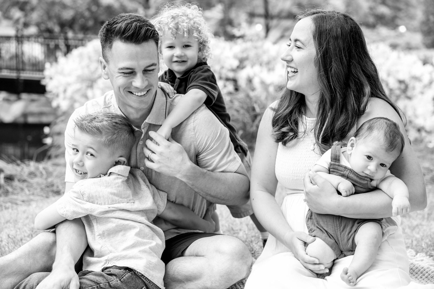 Black and white portrait of a family sitting together outdoors.